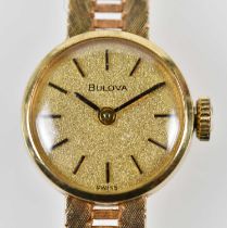 BULOVA; a lady's vintage 9ct gold wristwatch with baton markers to the circular dial and pierced