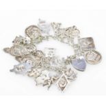 A silver charm bracelet set with many Scottish silver charms, approx 2.7ozt/85g.