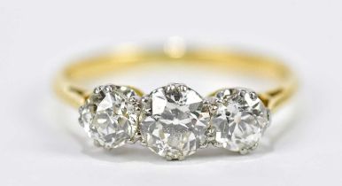 A yellow metal diamond three stone dress ring, the central stone approx .50 carats, flanked by two