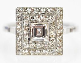 A white metal and diamond Art Deco ring with central square cut diamond weighing approx 0.50cts,
