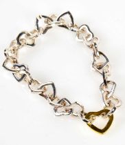 TIFFANY & CO; a sterling silver heart link bracelet, stamped T & CO 925, with bag and box.