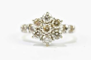 An 18ct yellow gold and diamond daisy head ring, the raised flower head set with seven diamonds with