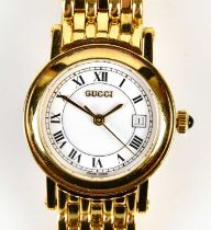 GUCCI; a gold plated lady's wristwatch with Roman numerals and date aperture to the white dial,