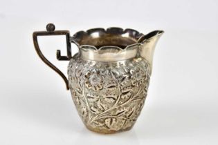 CT BURROWS & SONS; a Victorian hallmarked silver cream jug embossed with floral decoration