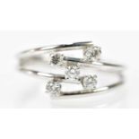 A white metal five stone diamond set ring with claw set brilliant cut stones set to three bands,