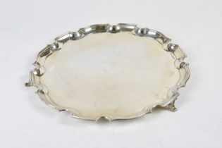 WILLIAM ADAMS LTD; a George V hallmarked silver salver with cast scalloped edge on sabre legs,