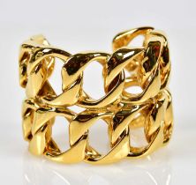 CHANEL; a broad hoop link double row cuff bangle with gold plated finish and oval applied plaque,