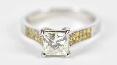 An 18ct white gold solitaire ring, the four claw set princess cut stone approx 1ct, with yellow