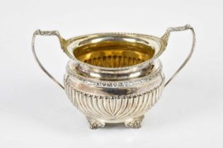 A George III hallmarked silver twin handled sugar bowl with traces of gilded interior and part