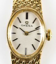 OMEGA; a lady's vintage 9ct yellow gold wristwatch, the oval dial set with baton markers and with