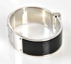 HERMÈS; a black enamel and silver Charniere bracelet with Hermès embossed to side, 7cm across, in