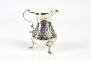 A Victorian hallmarked silver cream jug of baluster form, embossed with floral decoration and gilded