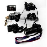 A collection of cameras to include a Canon SureShot point-and-shoot film camera, a Zenit-E SLR