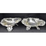 A pair of Victorian hallmarked silver heart-shaped dishes with pierced scroll sides, raised on three