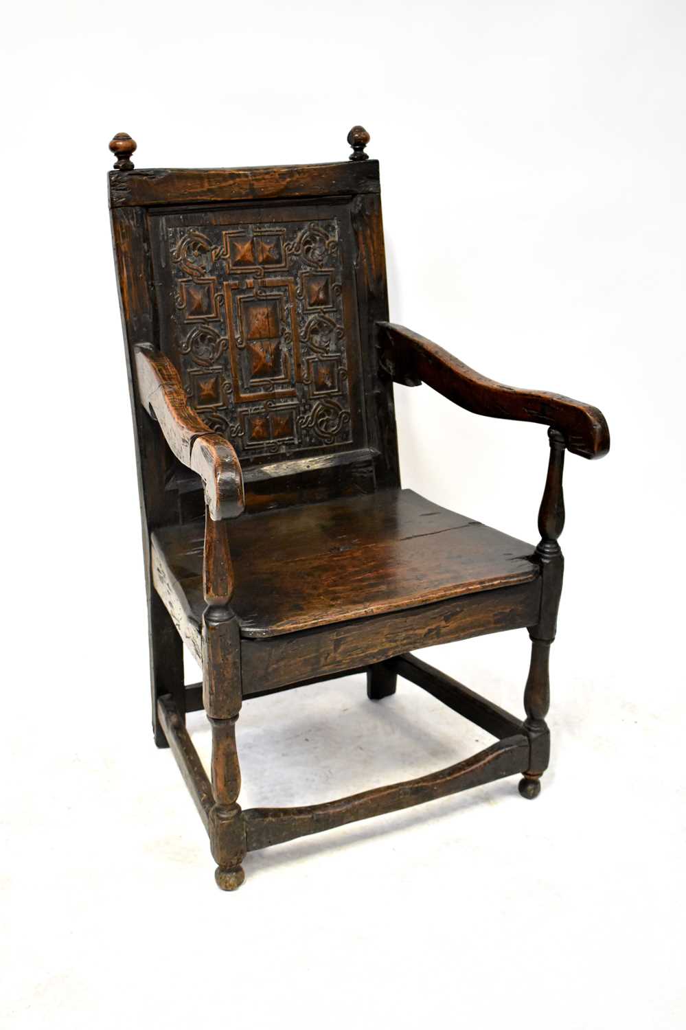 A 17th century and later Wainscot type open armchair with corner finials to the top, panel back