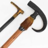 Two vintage walking sticks comprising one with curved ram's horn tip and hoof handle, the shaft