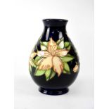 MOORCROFT; a baluster vase with cobalt blue ground in tube lined 'Clematis' pattern, height 19.5cm.