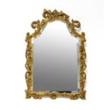 An ornate gilt framed Rococo-style arched mirror with scrolling foliate frame, 81 x 54cm.