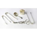 A small quantity of silver tableware items comprising three sugar tongs, grape tongs, a shell-form