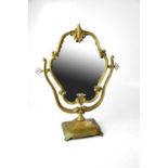 An Edwardian-style brass swing mirror with shell finial to the top, to square stepped base and