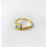 An 18ct yellow gold crossover ring set with pale green oval stone, size N, approx. 4g.