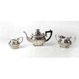 An Edward VII hallmarked silver three-piece tea service, the teapot with ebonised handle and finial,