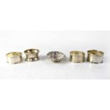 Four hallmarked silver napkin rings and a hallmarked silver pin dish, various marks, combined