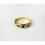 An 18ct yellow gold ring set with two small diamonds and three blue stones, size L 1/2, approx. 3.