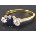 An 18ct gold diamond and sapphire ring, the central claw set marquise cut sapphire flanked by two