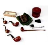 A collection of pipes to include two with silver collars, a leather covered tobacco bowl with lid,