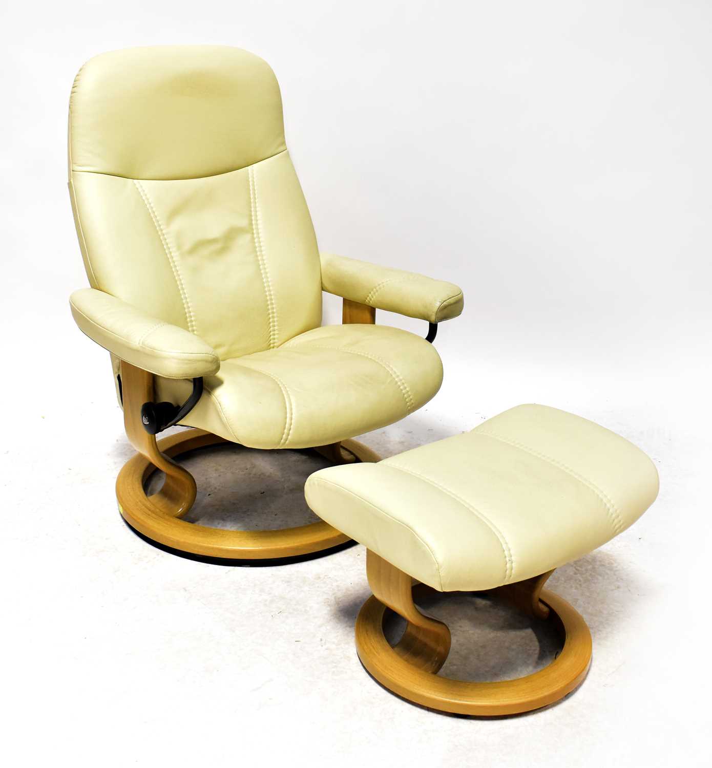 EKORNES; a stressless leather armchair in cream with matching footstool.