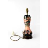 MOORCROFT; a waisted baluster lamp in tube lined 'Honeysuckle' pattern, to circular stepped base,