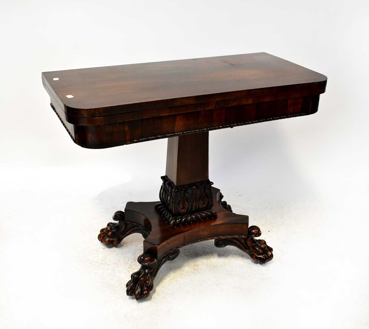 A Victorian rosewood fold-over table to rectangular column support with carved acanthus leaf