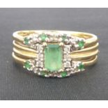 A vintage diamond and emerald bridal set ring, the central emerald cut stone flanked by three tiny