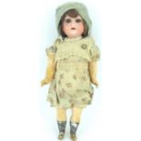 A 19th century small German porcelain and composite doll with sleepy eyes and open mouth, marked '