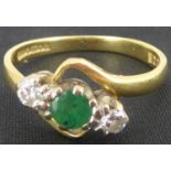 An 18ct gold diamond and emerald ring, the central emerald flanked by two tiny diamonds, size L,