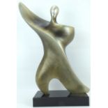 A large modern decorative sculpture of an abstract dancer raised on black polished slate base,