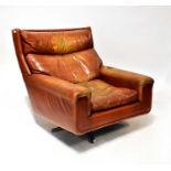 A retro oversized tan leather lounge chair raised on four outswept alloy supports (af).