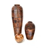 Three large modern stained wood floor-standing vases comprising a three-section Ali Baba style