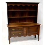 A Georgian-style oak dresser with enclosed plate rack above a base of two drawers with a cupboard