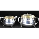 BARKER BROTHERS; a George V hallmarked silver three-handled sugar bowl and matching cream jug,