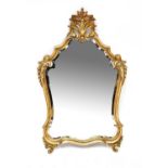 A 20th century Rococo-style gilded wall mirror with large shell and floral finial to the top and
