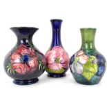 MOORCROFT; three various tube lined floral patterned vases, comprising one of bottle shape with blue