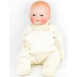 An early 20th century bisque head doll with sleepy eyes, closed mouth and bald head, with