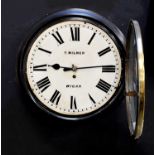 T. MILNER OF WIGAN; a late 19th century circular station clock in ebonised frame, the cream dial set