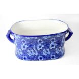 A 20th century blue and white twin-handled foot bath with printed anemone, nasturtiums and leaf
