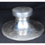 An Edwardian hallmarked silver capstan-style desk inkwell of circular shape, with weighted base,