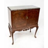 A reproduction burr walnut cocktail cabinet with pair of panelled doors enclosing a mirrored and