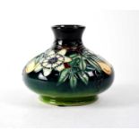 MOORCROFT; a squat baluster vase, green drip glaze ground with tube lined 'Passionflower', marked to