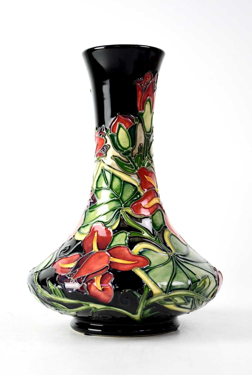 MOORCROFT; a baluster vase of cylinder form with black ground and tube lined floral decoration,